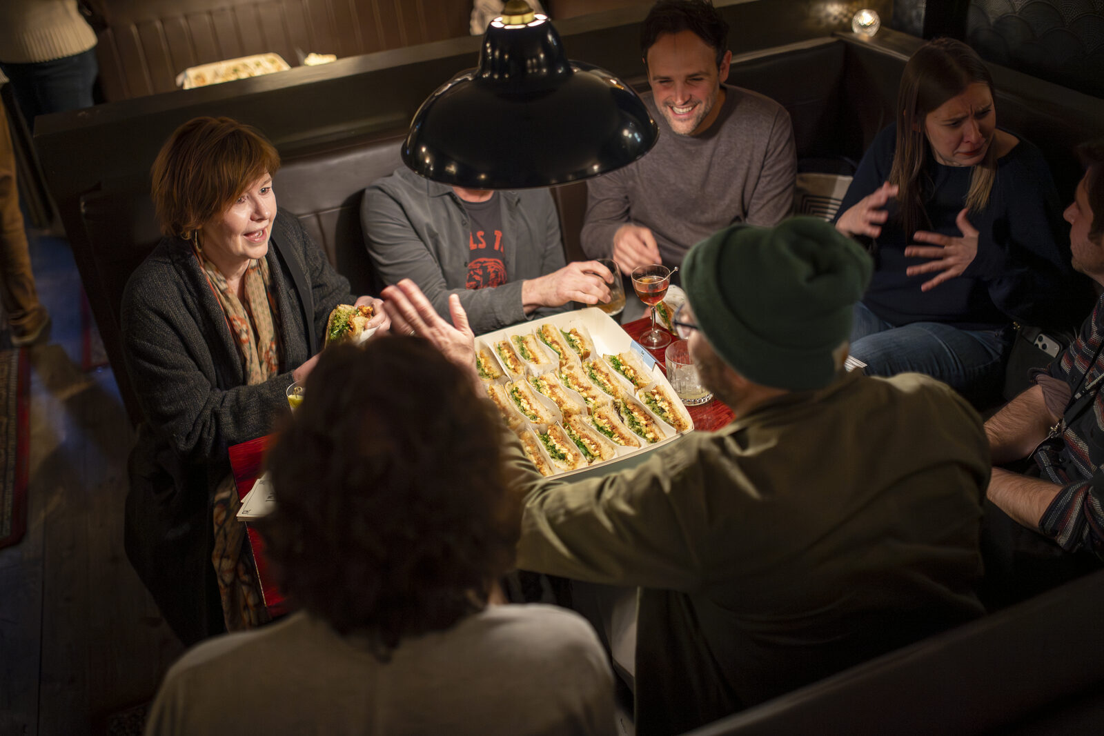 Friends enjoying a La Posata focaccia catering spread at an event