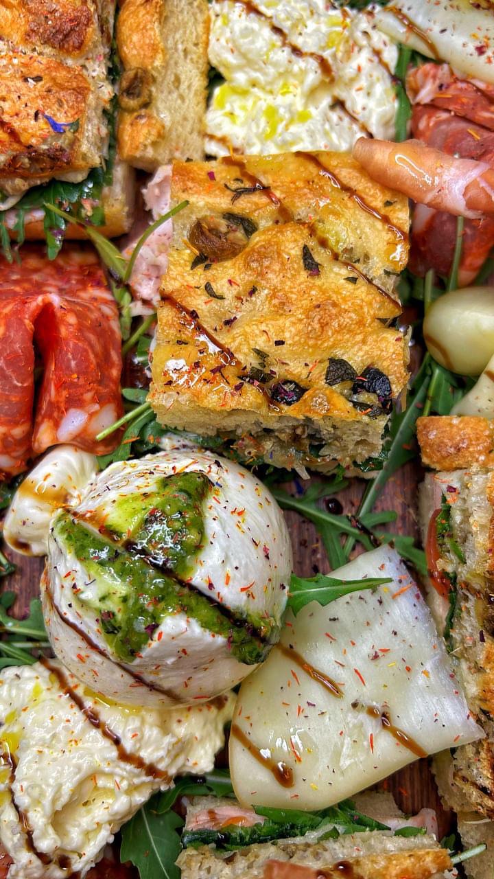 Focaccia med oliven ved siden af burrata og pesto verde